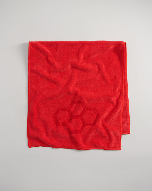 A vibrant red towel with a subtle hexagonal pattern showcasing both texture and color in a minimalist design