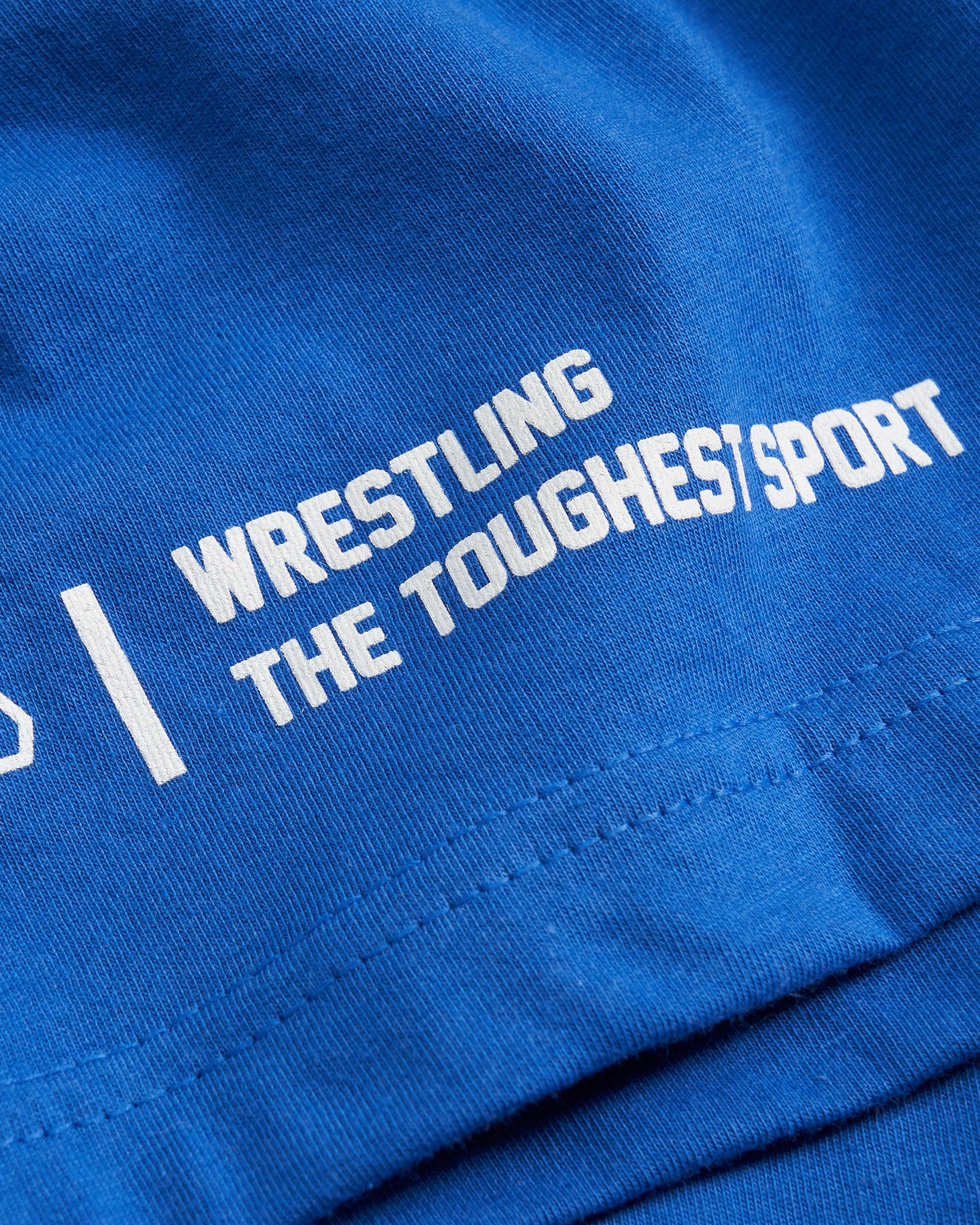 A close-up view of a vibrant blue fabric featuring bold white text that reads WRESTLING | THE TOUGHEST SPORT