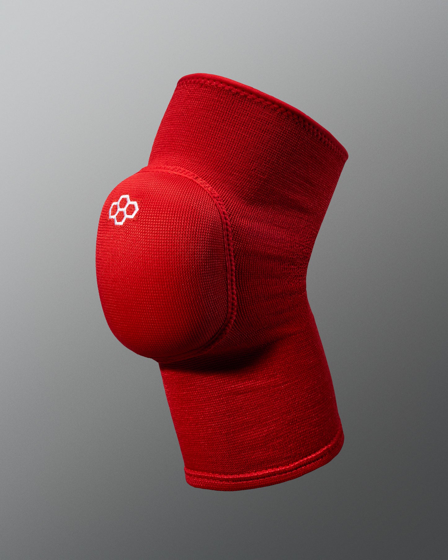 A vibrant red knee sleeve featuring a padded support area designed for athletic use and injury prevention