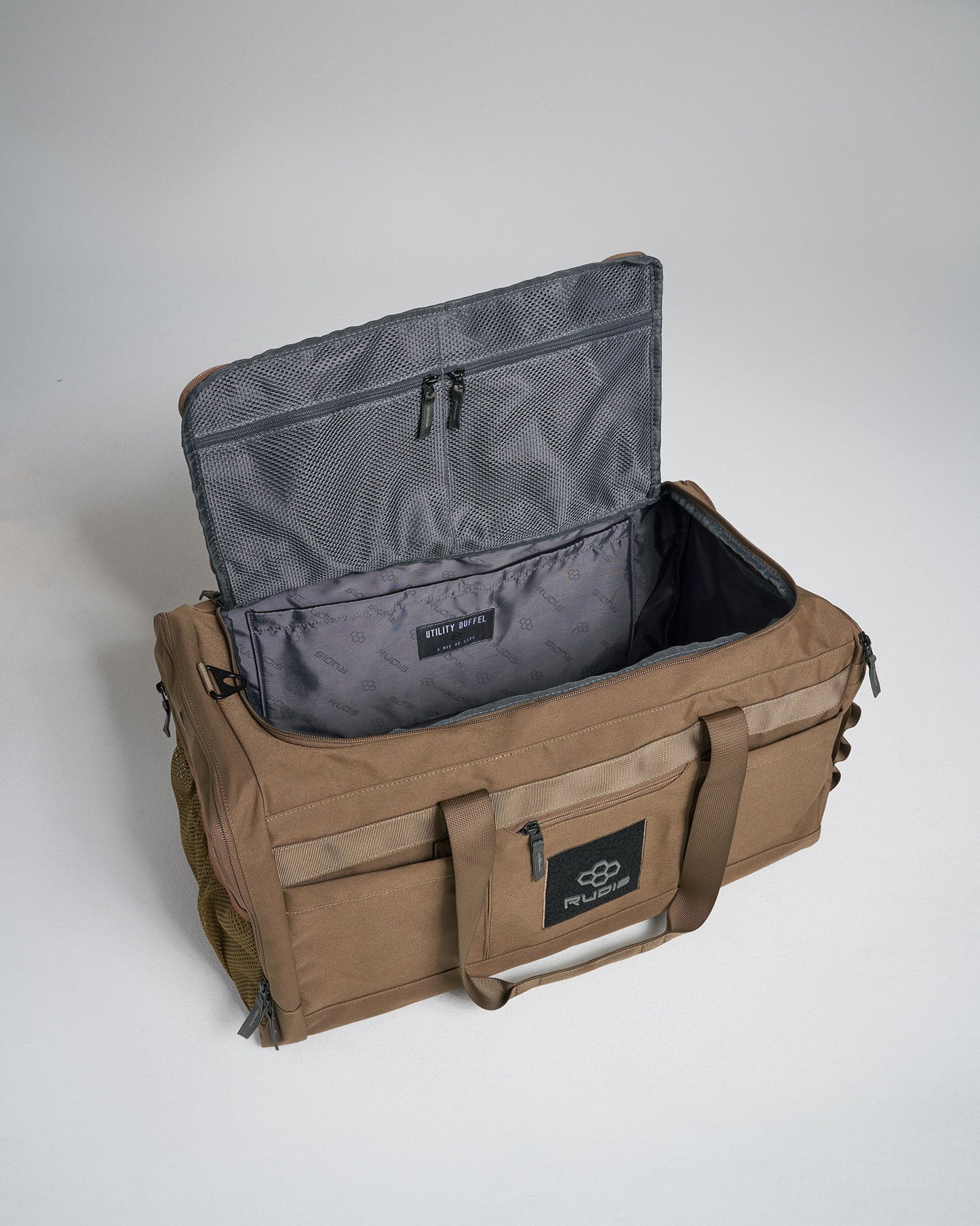 A spacious brown utility duffel bag with a gray interior and multiple compartments ideal for travel or gym use