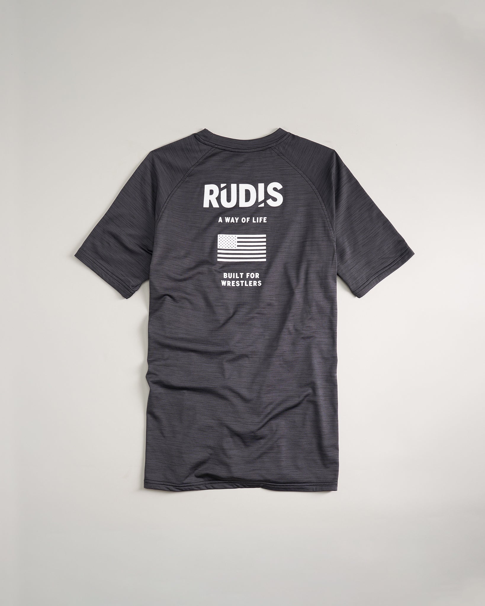 A sleek black athletic shirt featuring bold white text and a graphic of the American flag designed specifically for wrestlers