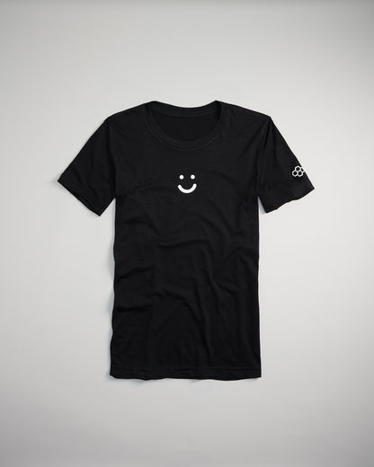 A classic black t-shirt featuring a simple white smiley face design on the front and a unique graphic on the sleeve