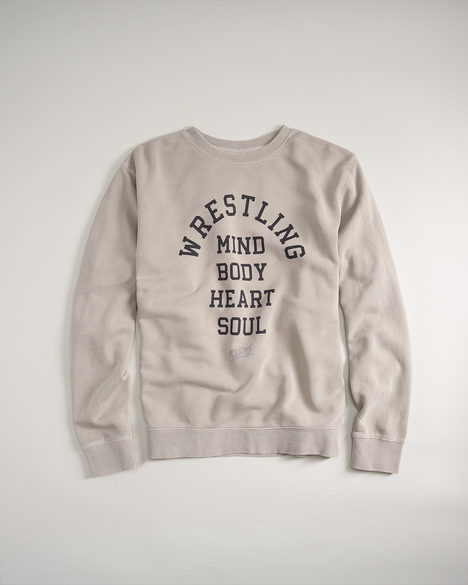 A gray sweatshirt featuring the text WRESTLING MIND BODY HEART SOUL in bold black lettering capturing the essence of wrestling and its holistic demands