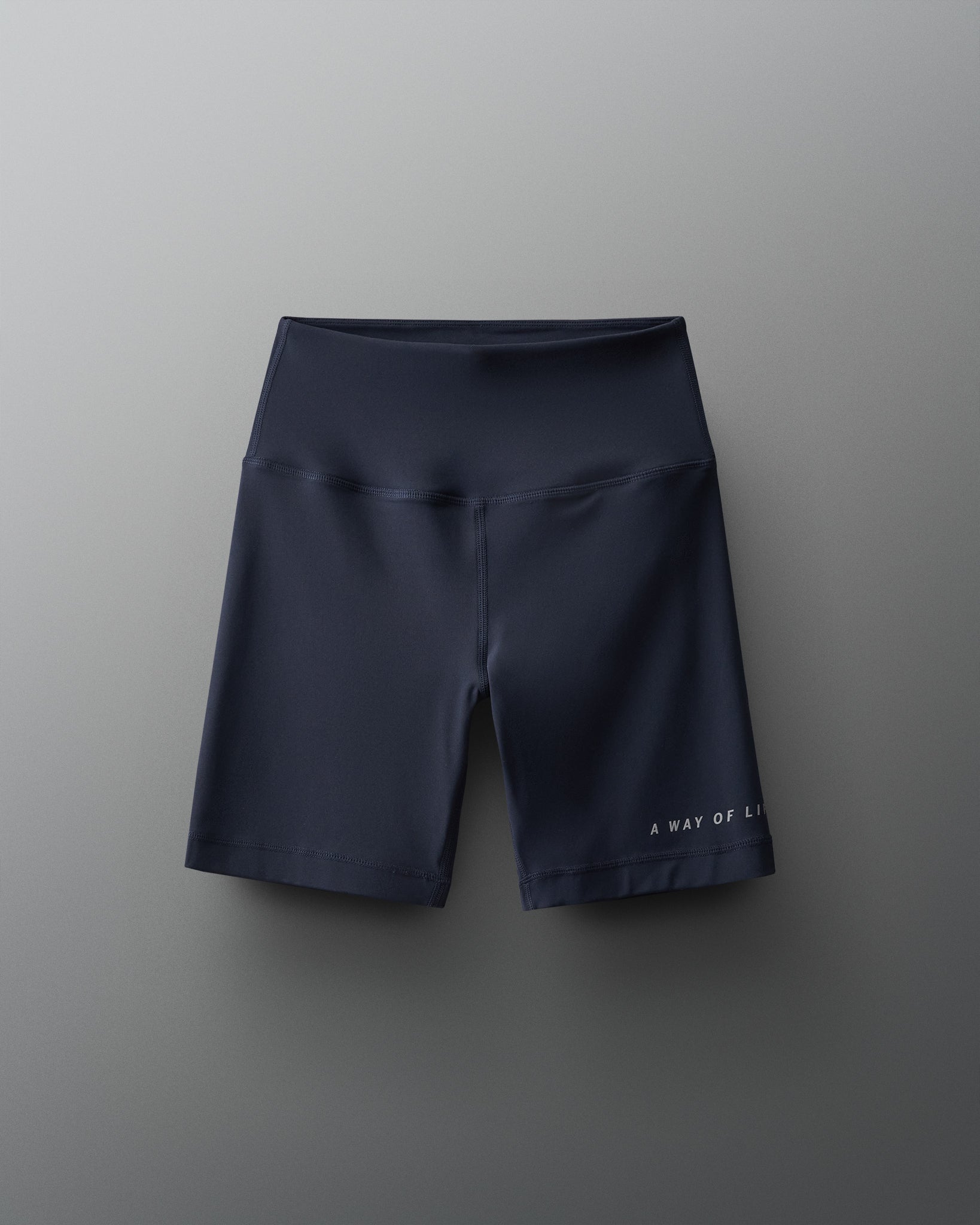 The image showcases a pair of sleek dark navy cycling shorts with a wide comfortable waistband and a subtle logo detail on the leg designed for both performance and comfort during athletic activities