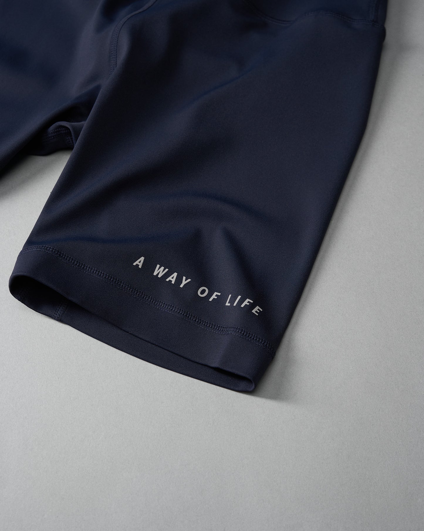 Navy blue athletic shorts featuring a motivational phrase printed on the hem suitable for workouts and casual wear