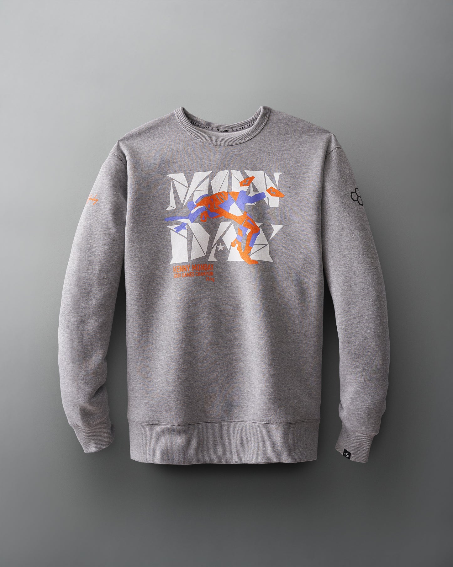 Gray sweatshirt featuring a vibrant 'MONDAY' graphic and a dynamic orange and blue figure, paired with ribbed cuffs for a sporty look.