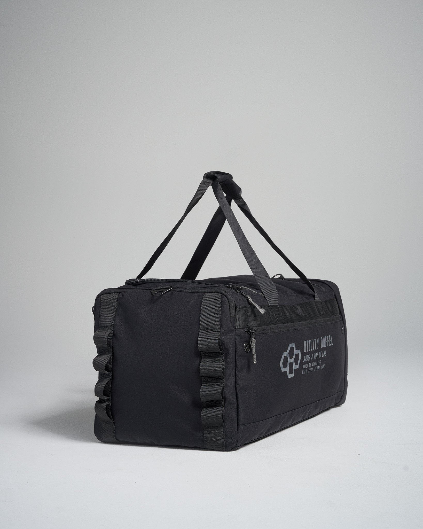 A sleek black utility duffel bag featuring sturdy handles and a minimalistic design with printed text suitable for travel or storage