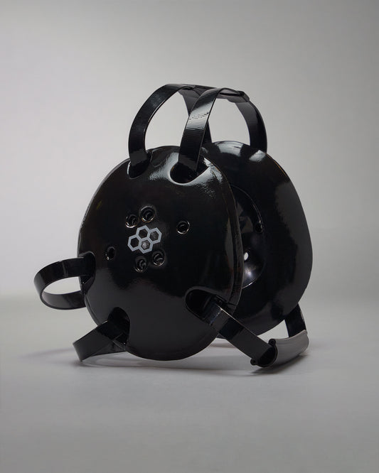 A rounded black protective helmet with ventilation holes and adjustable straps for a secure fit, ideal for safety in industrial or recreational contexts.