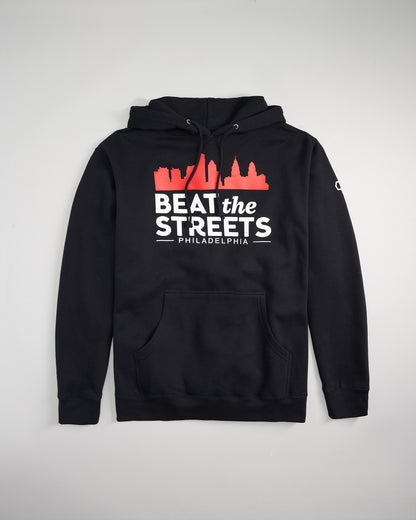 A black hoodie featuring a graphic design with the phrase BEAT the STREETS PHILADELPHIA and a skyline silhouette in red