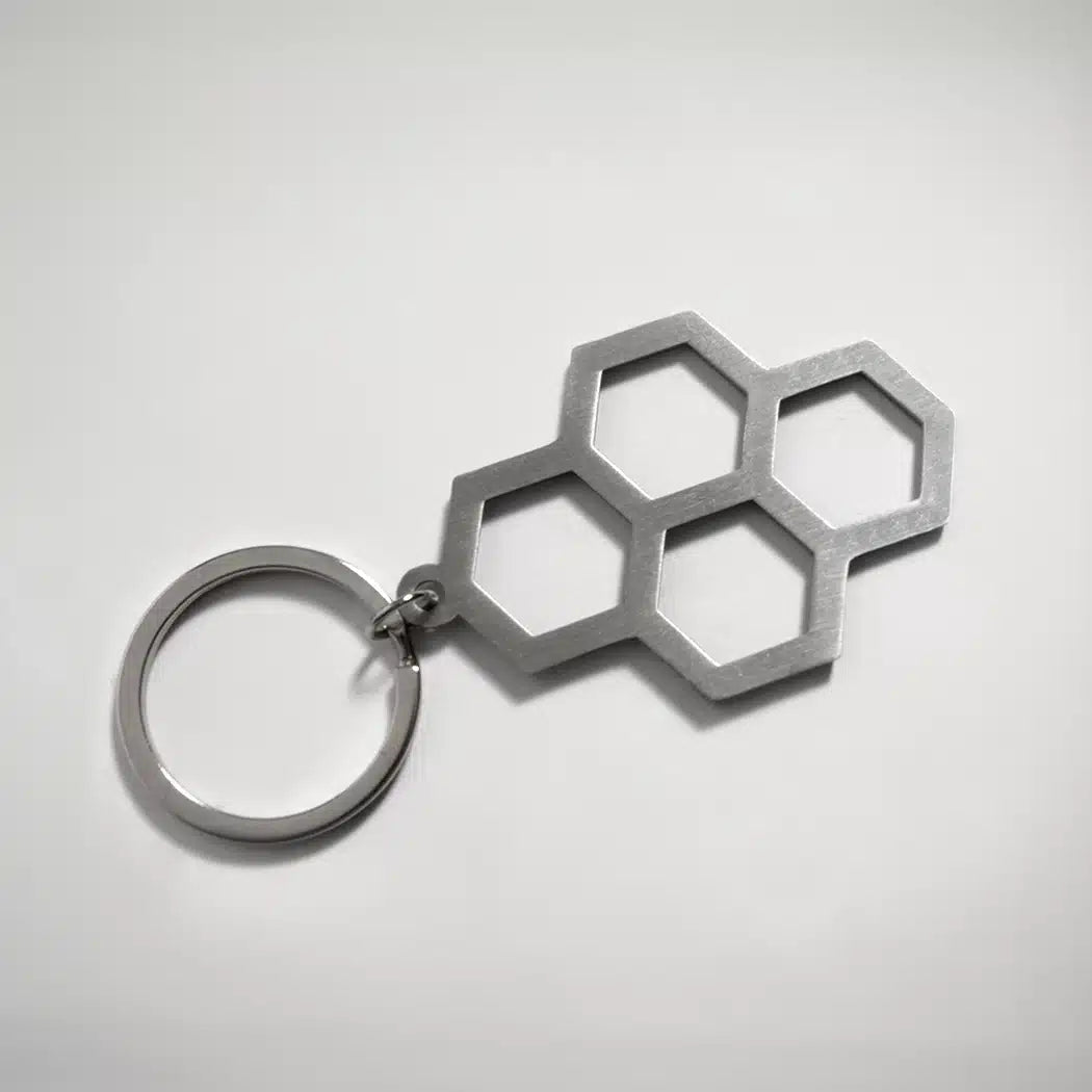 A modern silver keychain featuring a unique hexagonal design with three interlocking hexagons