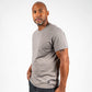 A well-built man poses confidently in a fitted gray t-shirt against a plain white background emphasizing casual style and comfort