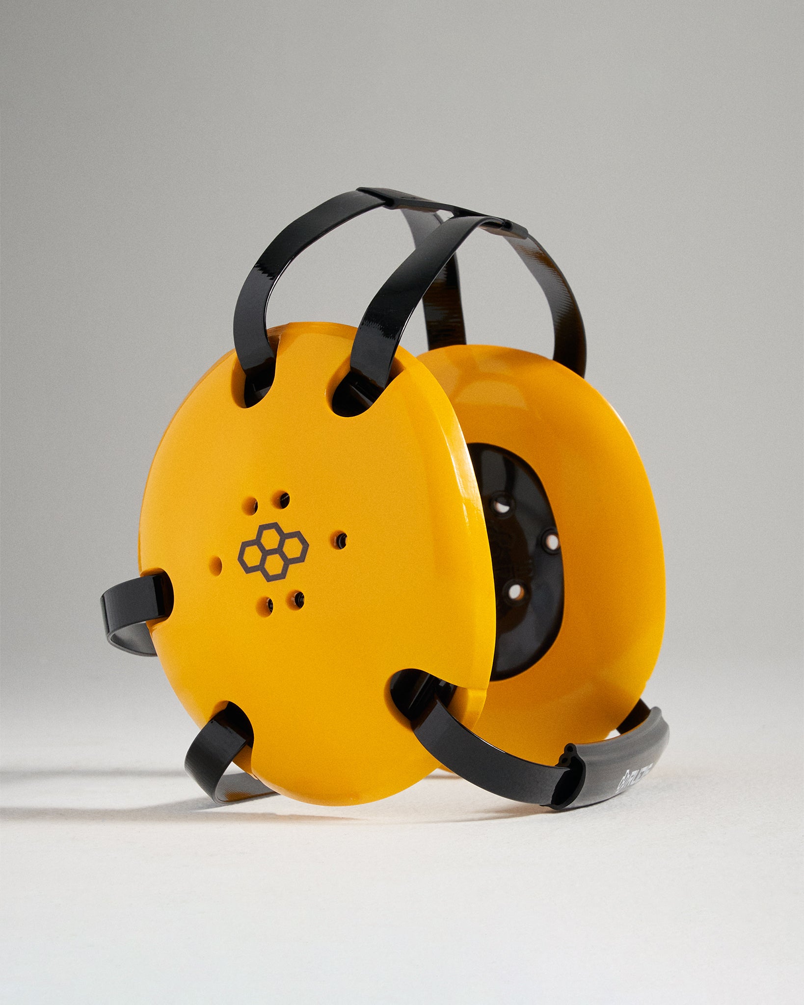 This image features a pair of bright yellow ear protectors with black straps designed for effective noise reduction and style placed against a soft gray background