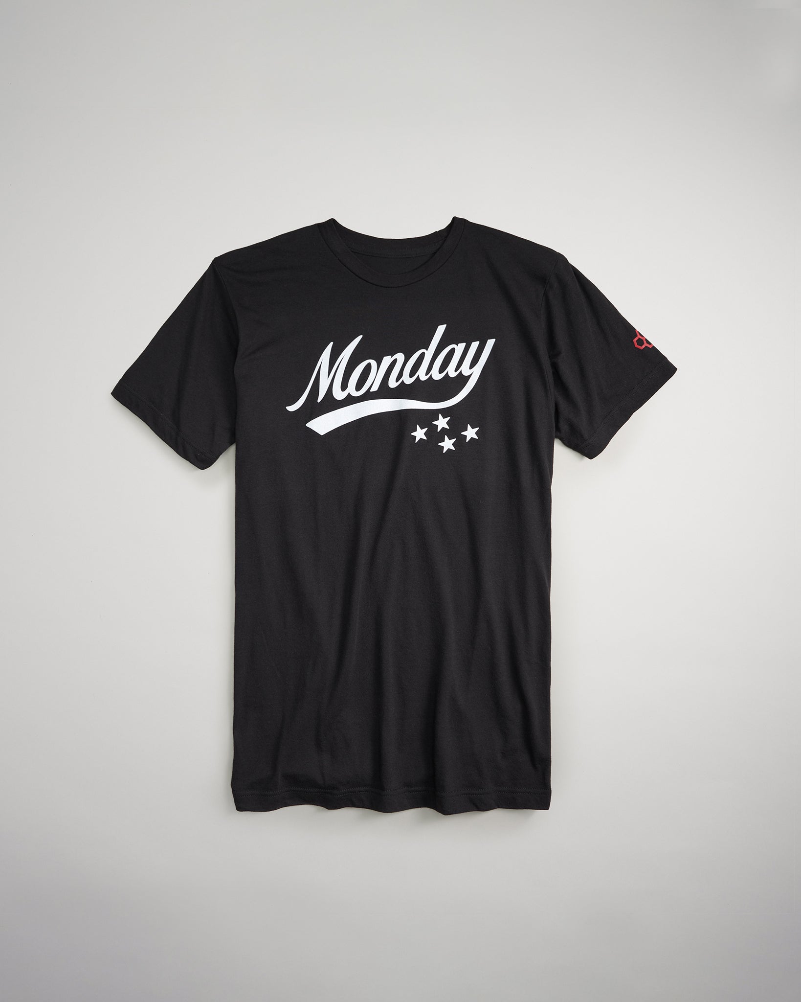 A black t-shirt featuring the word Monday in bold white lettering accented by three stars beneath the text