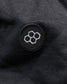 A close-up view of a black fabric displaying a circular embroidered logo featuring hexagonal shapes in white