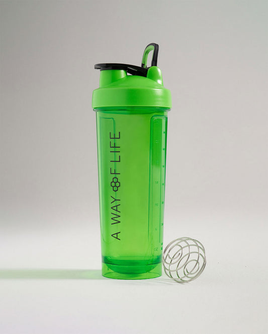 A bright green shaker bottle with a black lid featuring a measurement scale and a metal mixing ball beside it