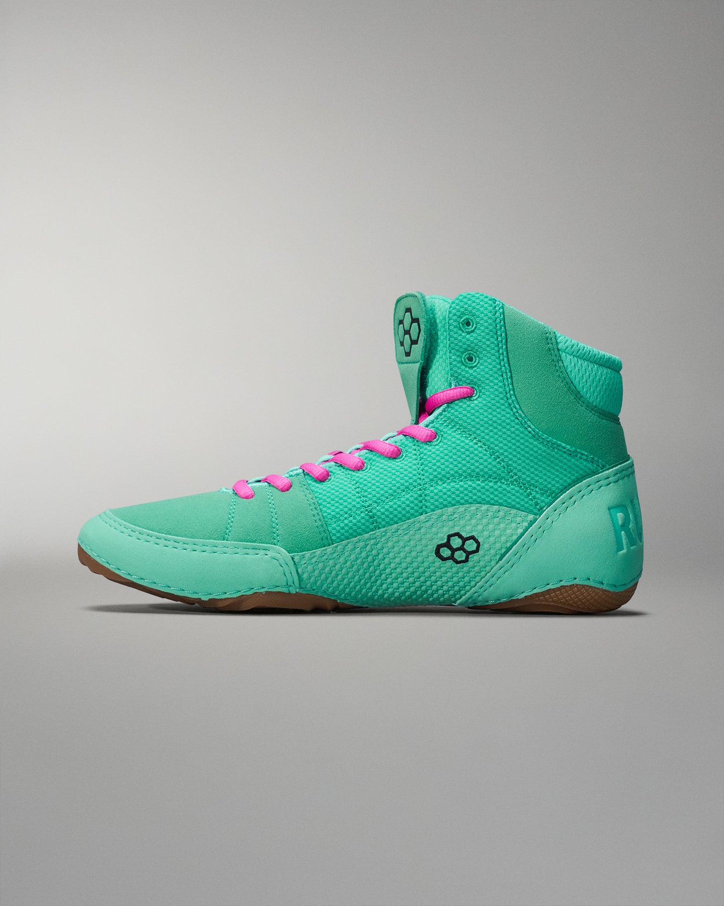 Bright turquoise high-top athletic shoe with pink laces, featuring a textured upper for grip and a durable rubber sole, against a soft gradient background.