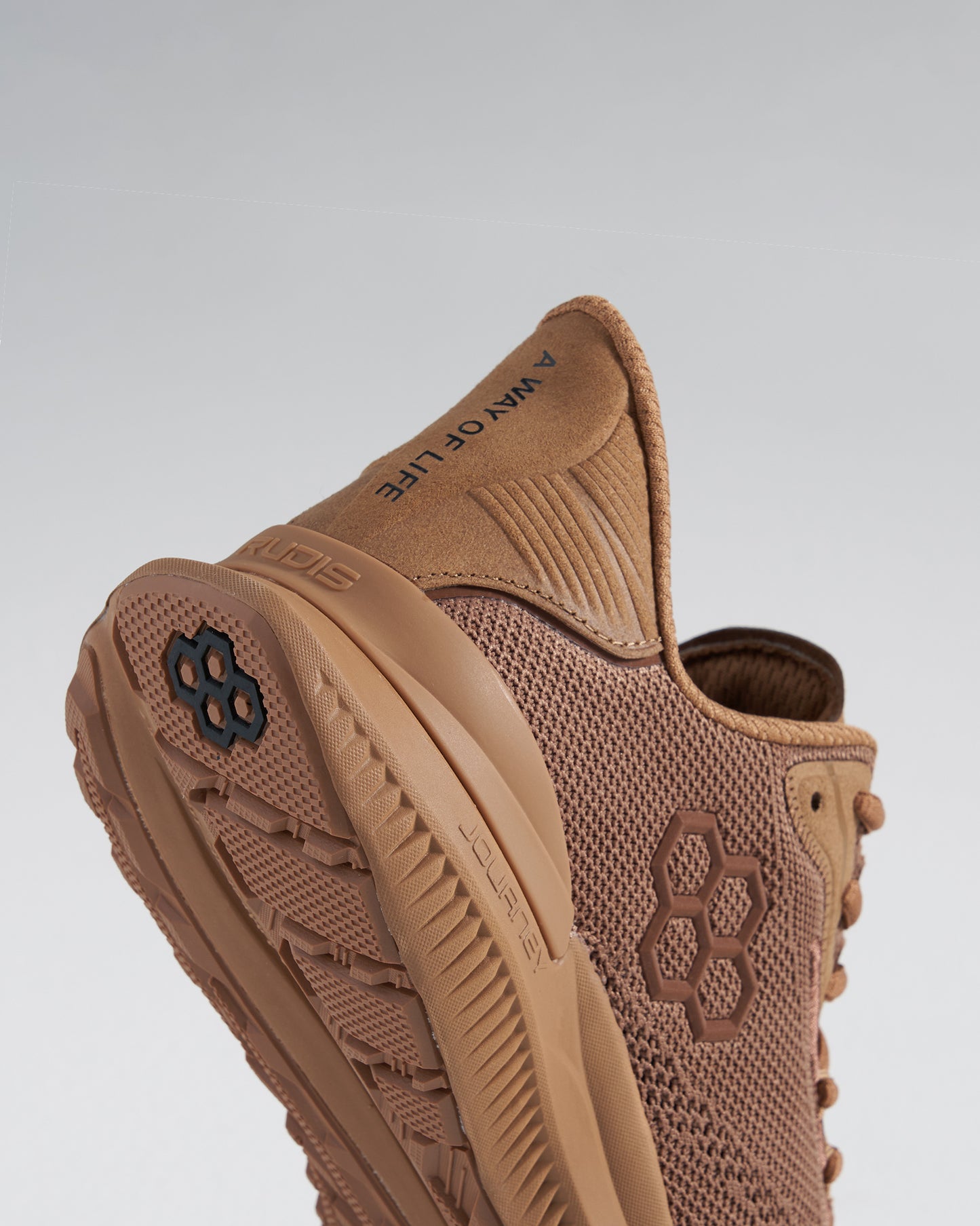 A close-up view of a brown athletic shoe featuring a mesh upper and textured sole for enhanced performance