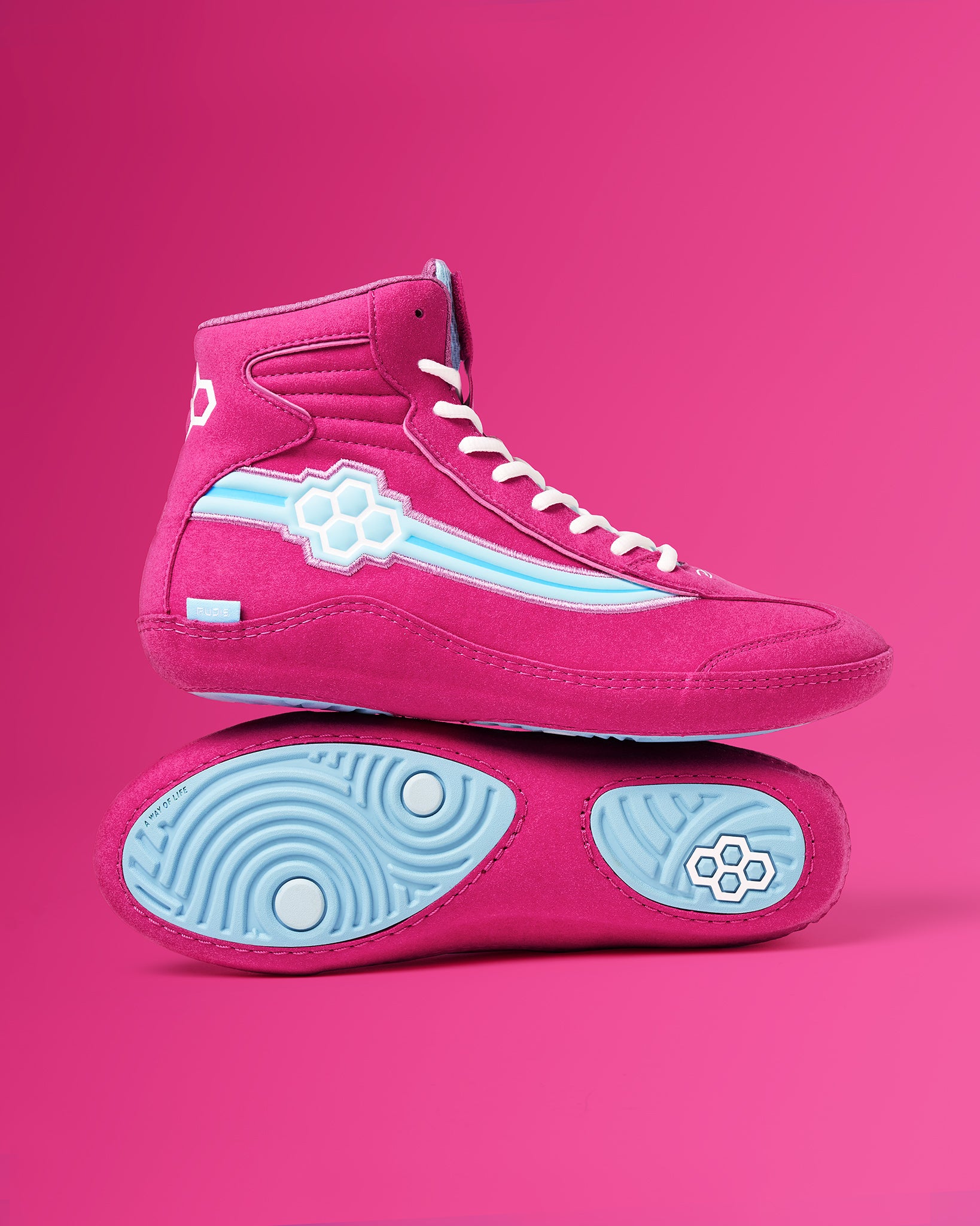 A vibrant pair of pink high-top sneakers with blue accents and a unique design showcased against a solid pink background