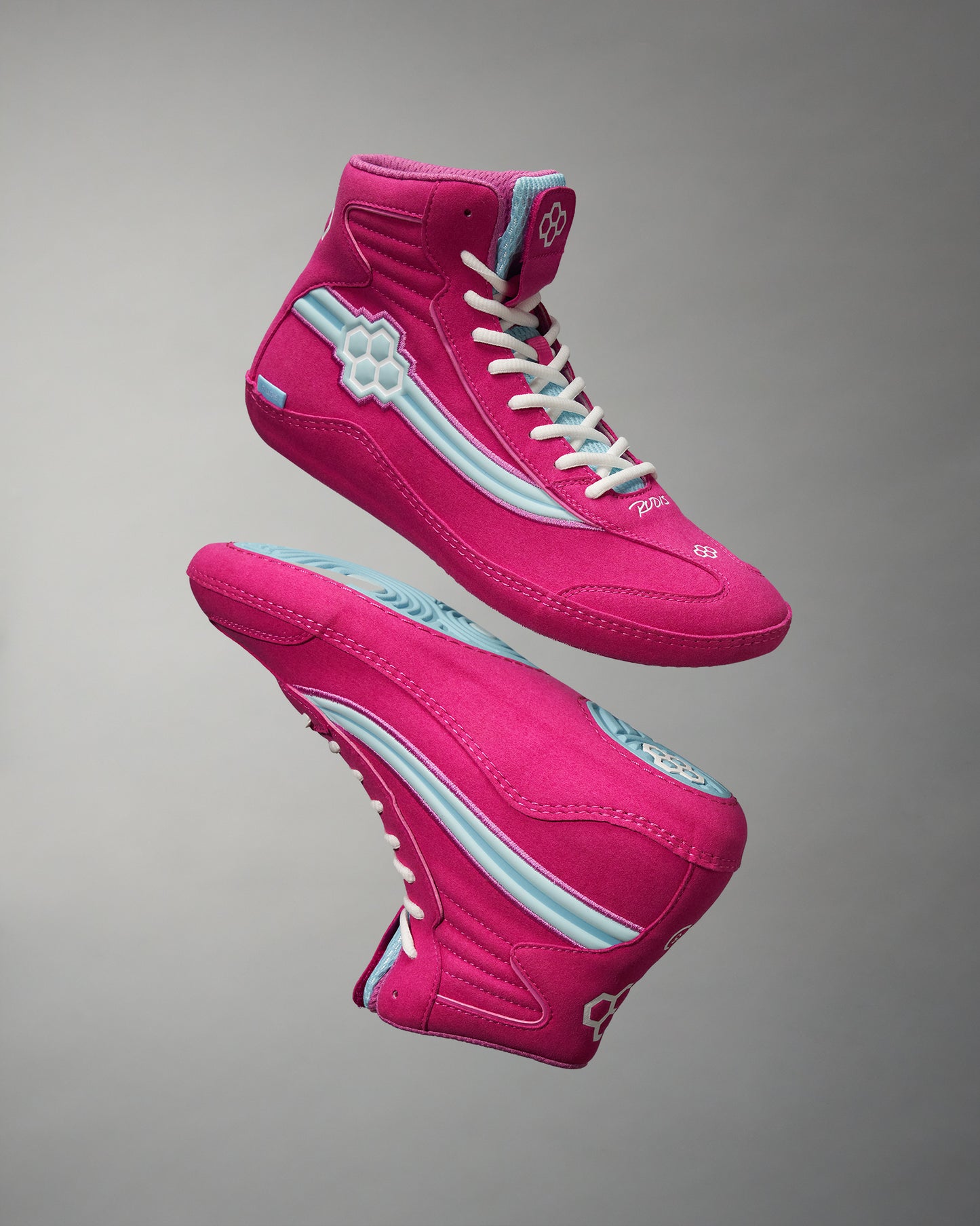 A vibrant pair of pink high-top sneakers featuring blue accents and white laces showcased against a neutral gray background