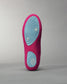 A close-up view of a vibrant pink shoe sole featuring a light blue tread design and textured grip elements