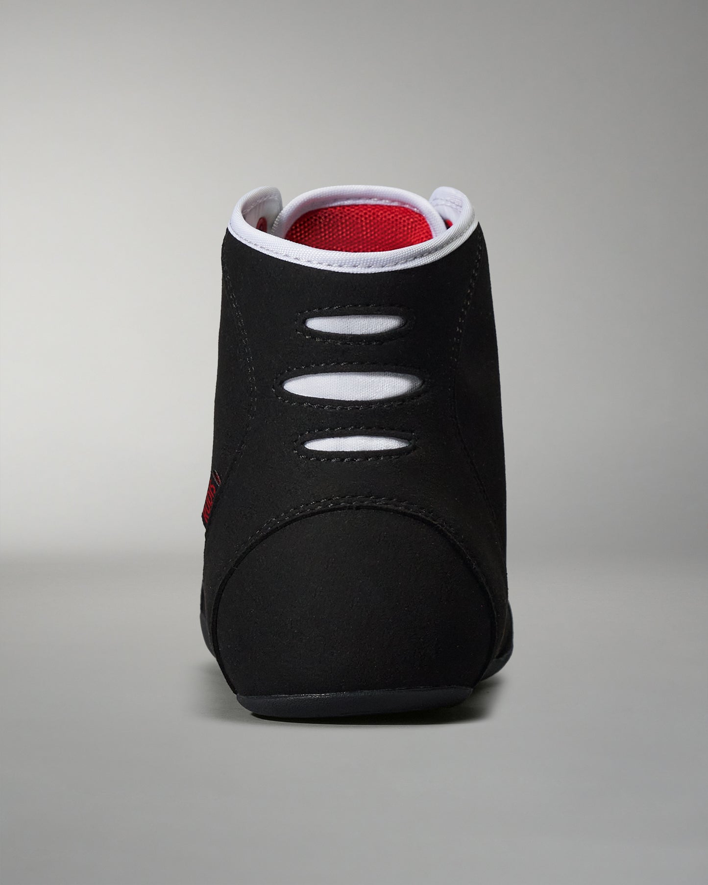 The back view of a black high-top athletic shoe with red mesh lining and white detailing, emphasizing its sleek design for sports and comfort.