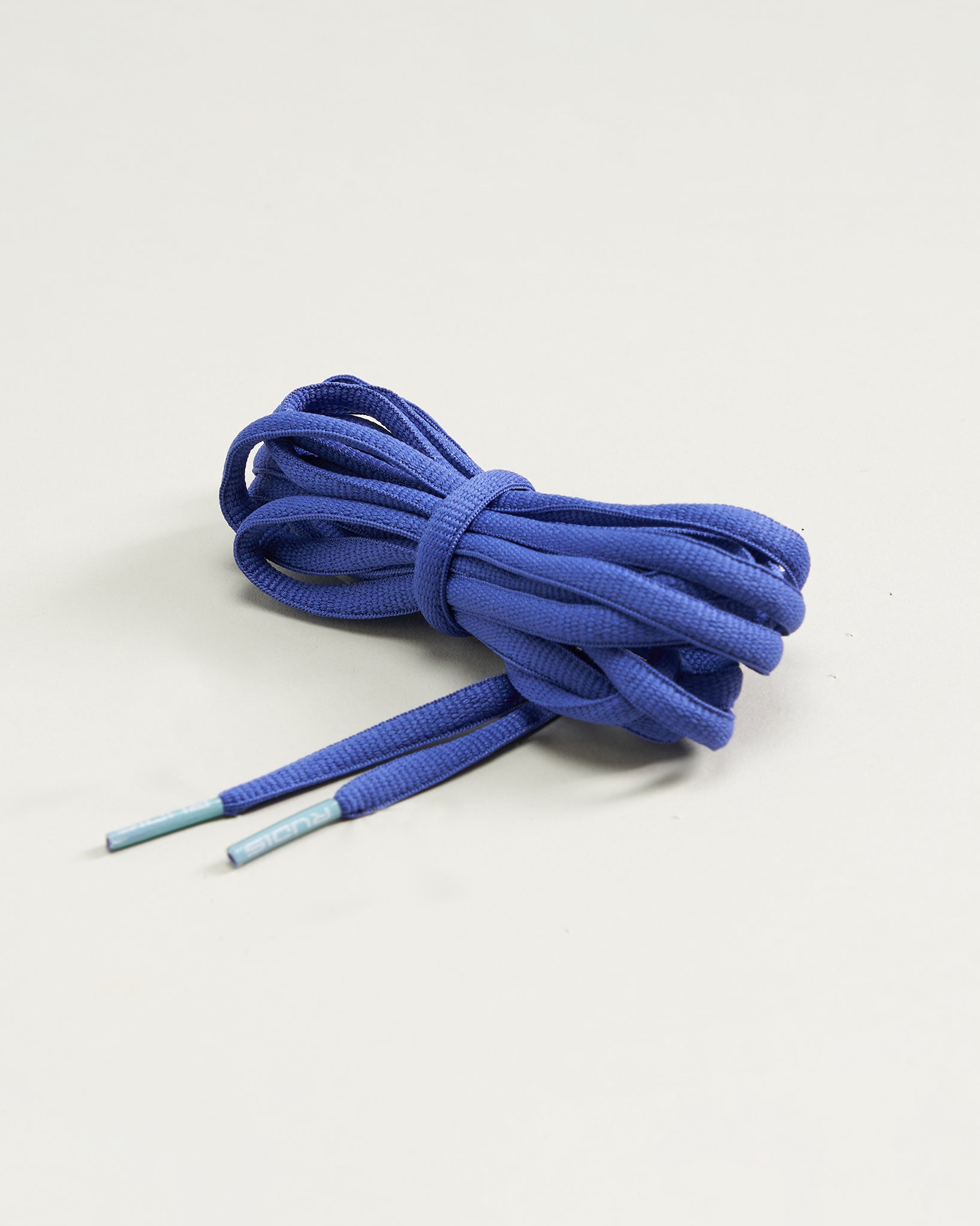 A bundle of blue shoelaces neatly coiled featuring plastic tips for easy threading into shoe eyelets