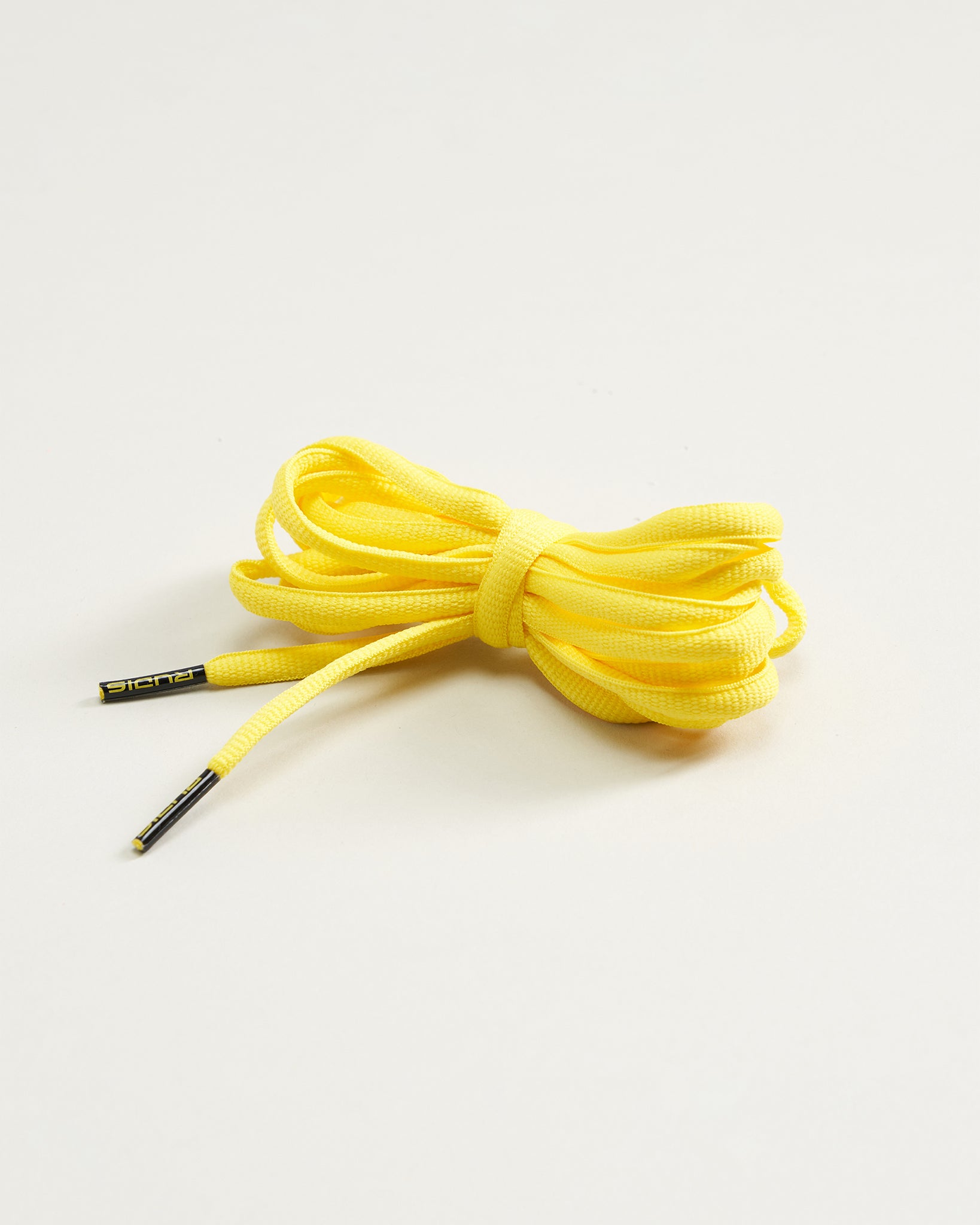 A bundle of vibrant yellow shoelaces with black aglets positioned neatly on a light background ideal for adding a pop of color to footwear