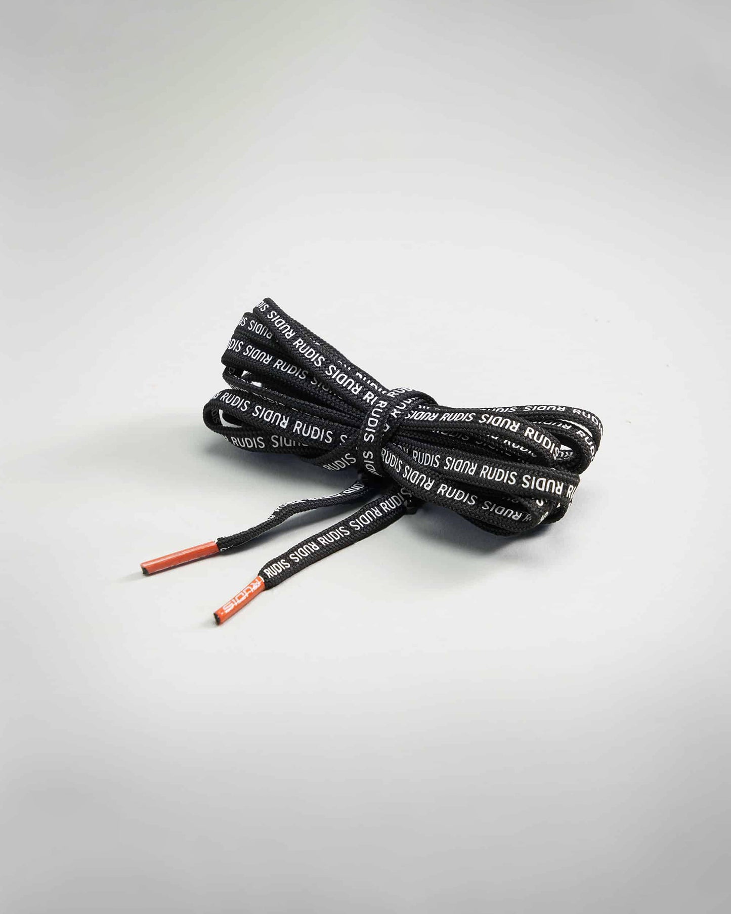 A bundle of black shoelaces with branding featuring contrasting colored tips