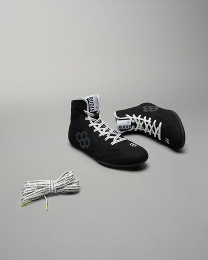 A pair of black wrestling shoes with a distinctive design and an additional set of branded laces