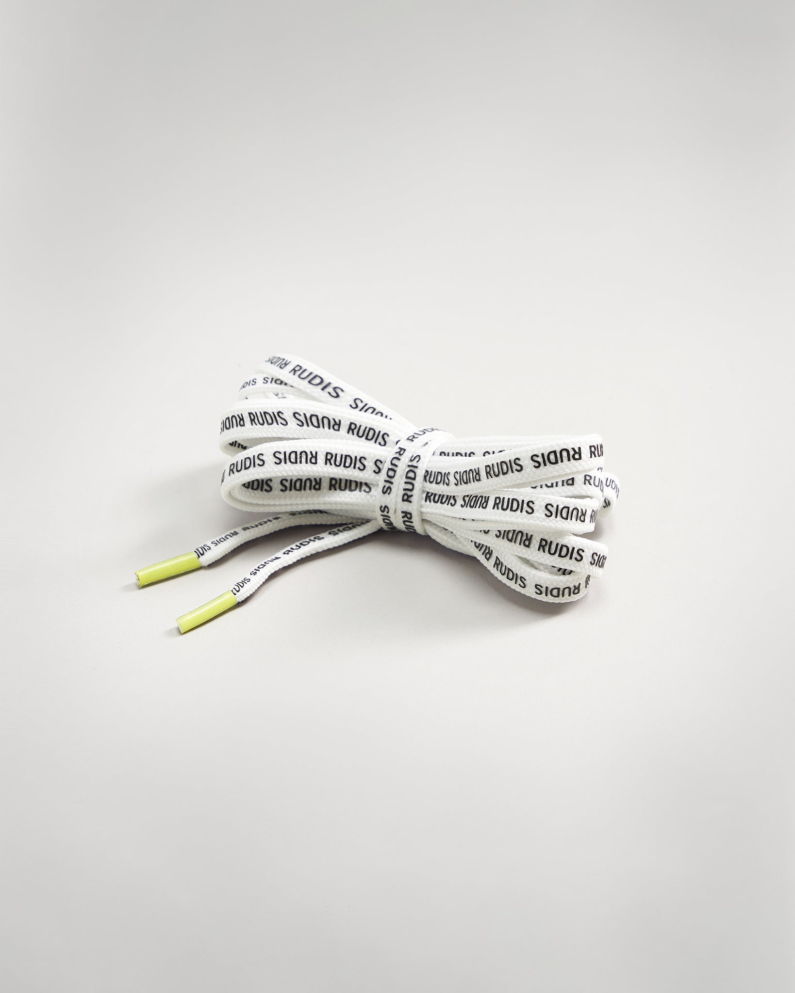 A pair of white shoelaces with black printed text design featuring yellow tips neatly tied in a bow against a light background