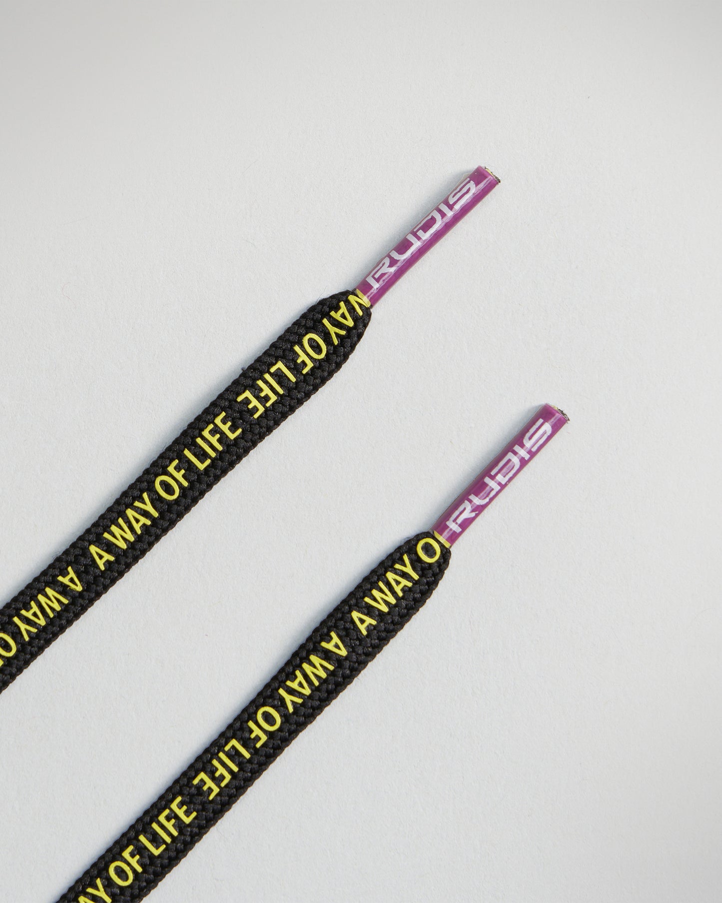 Black shoelaces inscribed with the phrase WAY OF LIFE and featuring distinctive purple tips labeled RUDIS