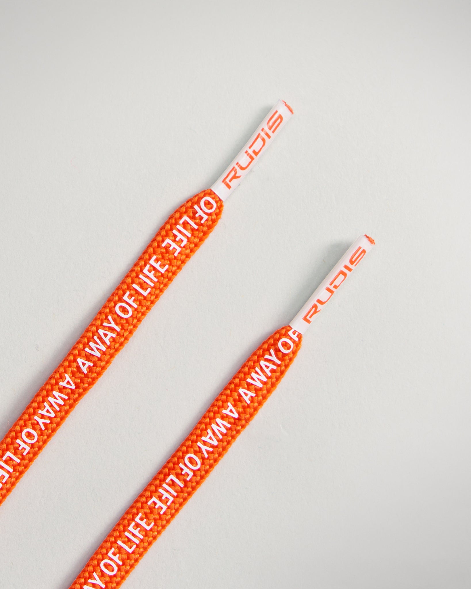 Bright orange shoe laces featuring the phrase A WAY OF LIFE and branded tips