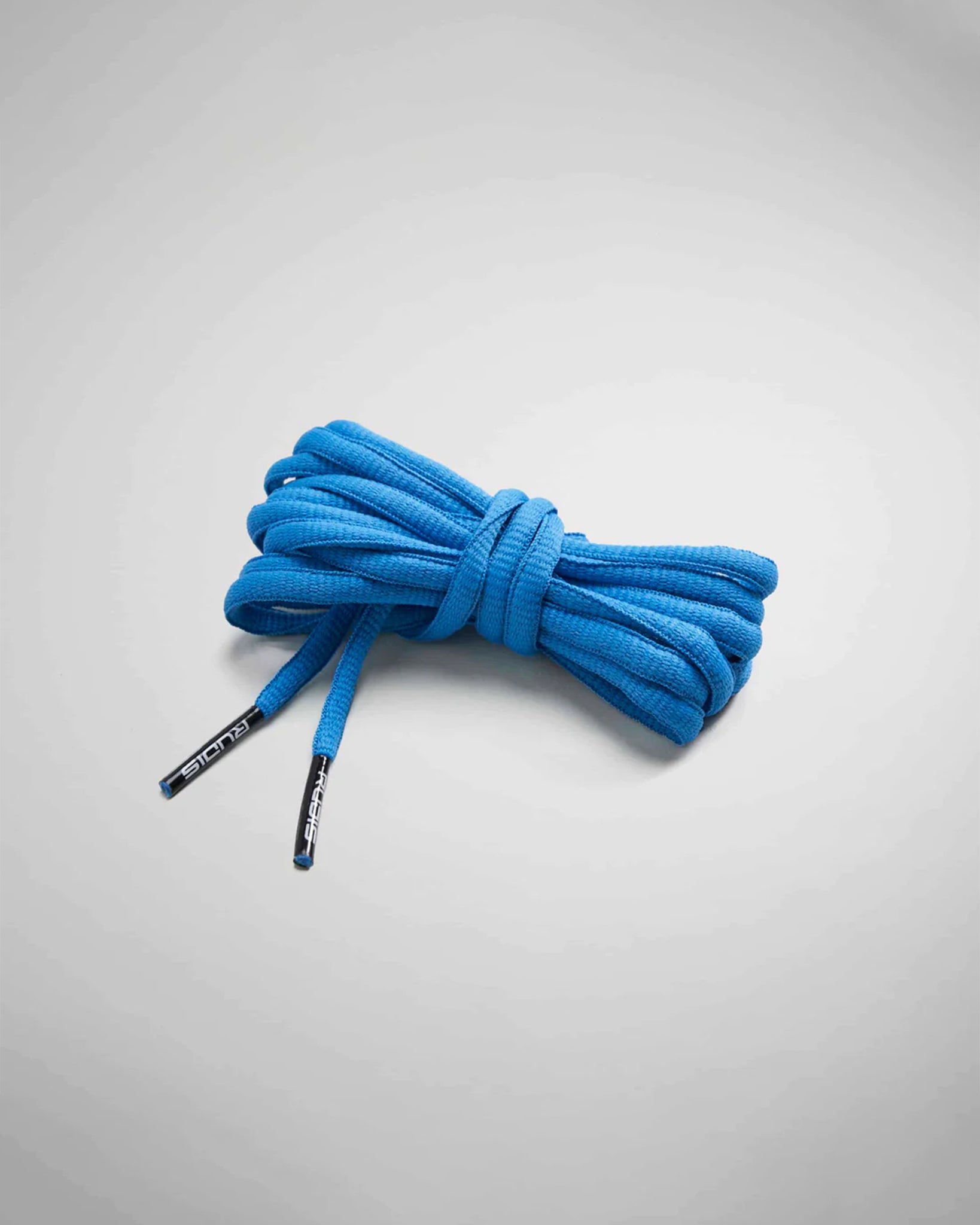 A neatly coiled bundle of vibrant blue shoelaces designed for athletic footwear featuring distinctive plastic tips