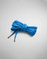 A neatly coiled bundle of vibrant blue shoelaces designed for athletic footwear featuring distinctive plastic tips