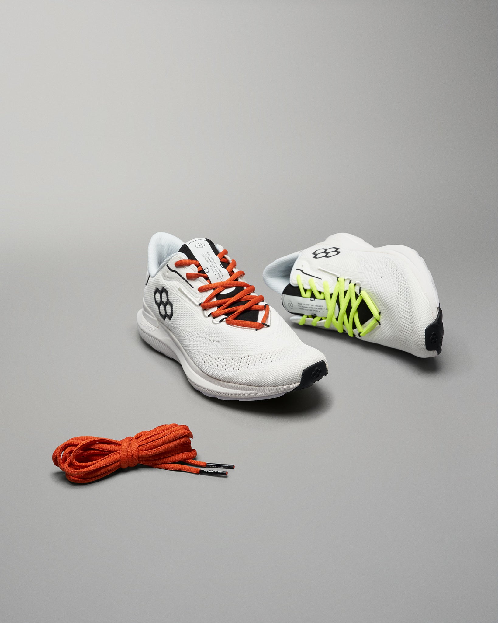 This image showcases a pair of modern white athletic shoes with vibrant laces emphasizing their sleek design and performance features