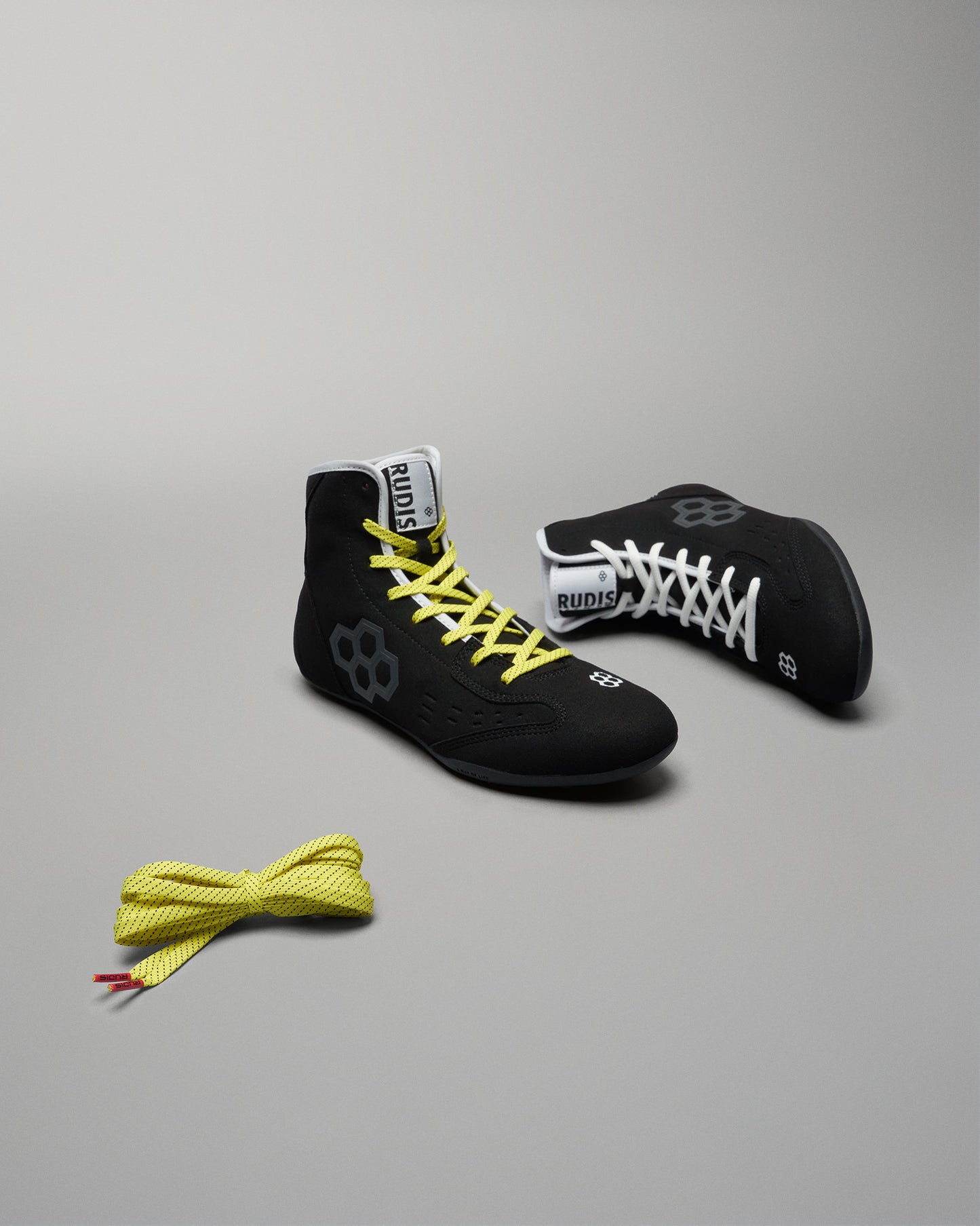 A pair of black wrestling shoes featuring contrasting laces showcasing both performance design and style