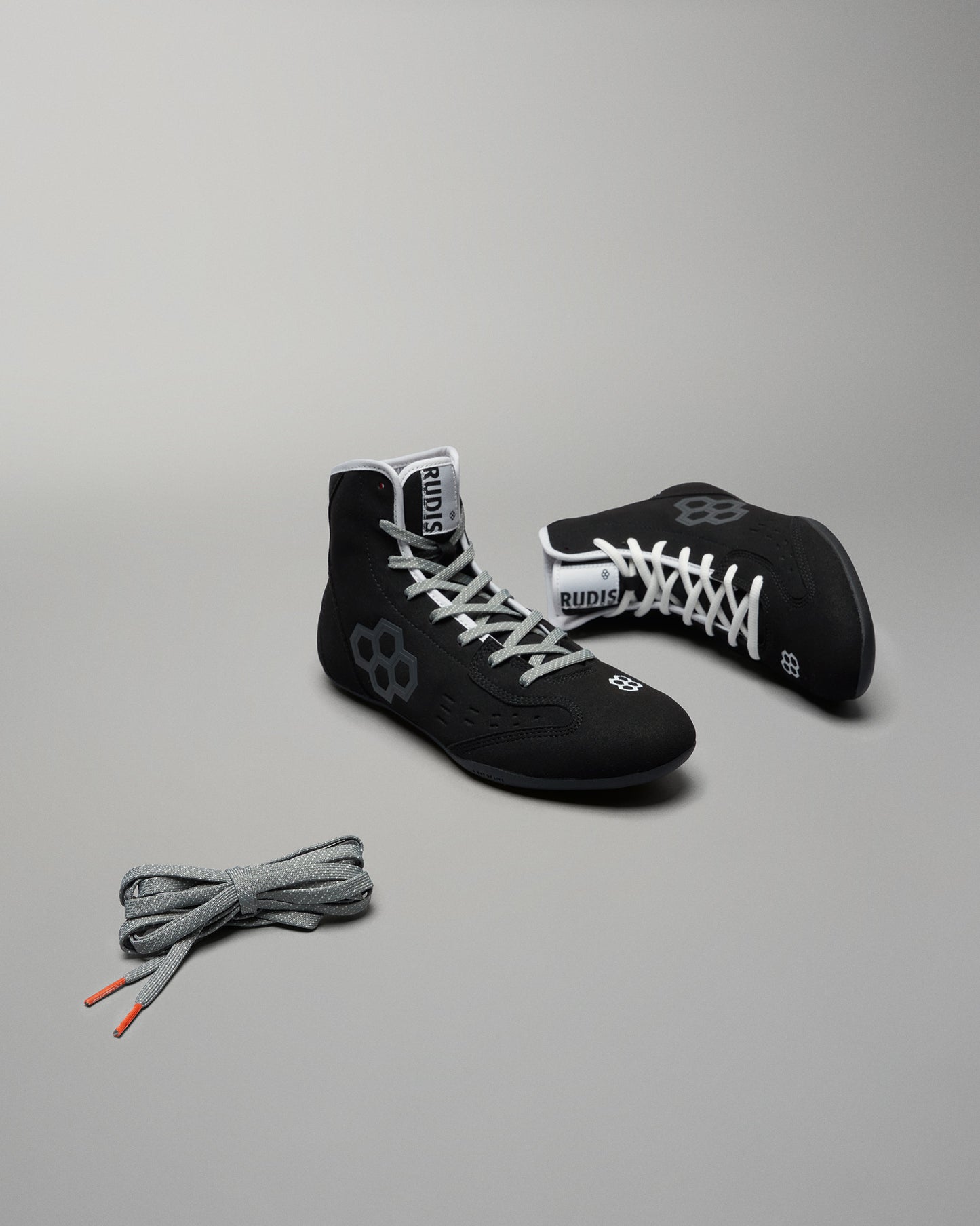 Black wrestling shoes with gray laces and a side view highlighting their modern design and flexibility