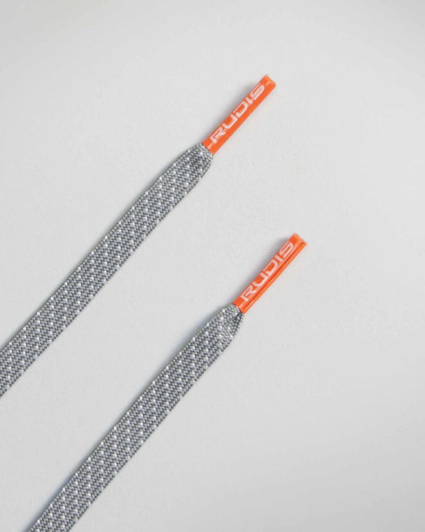 A pair of stylish grey shoelaces with orange tips featuring the brand name RUDIS printed on them