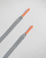 A pair of stylish grey shoelaces with orange tips featuring the brand name RUDIS printed on them