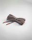 A neatly coiled grey shoelace with red tips designed for both functionality and style