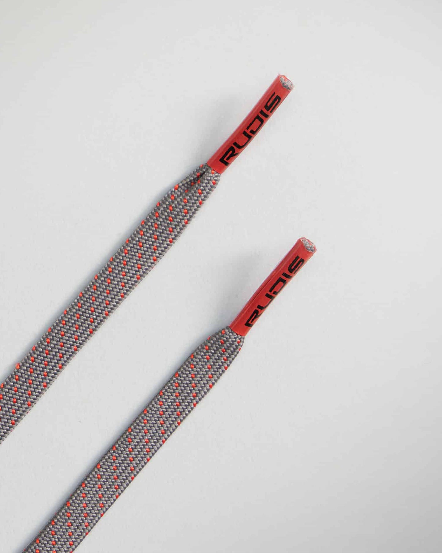 This image features a pair of gray and red shoelaces with a textured design showcasing red tips and branding for a stylish athletic appearance