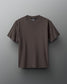 A dark olive green t-shirt with a round neckline is set against a textured gray background, featuring the brand 'RUDIS' on the inside label, creating a modern and minimalist presentation.