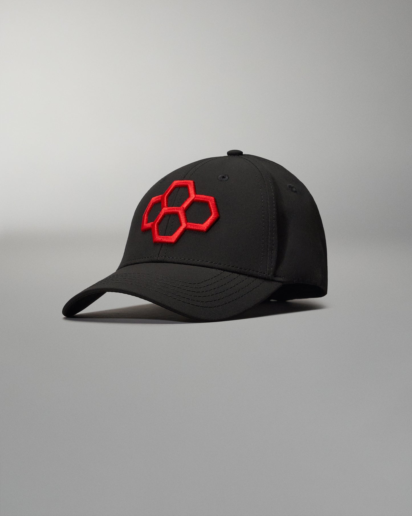 A sleek black cap featuring a bold red hexagonal logo on the front designed for style and comfort