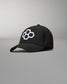 A stylish black cap featuring a distinctive white hexagonal logo on the front set against a minimalist gray background