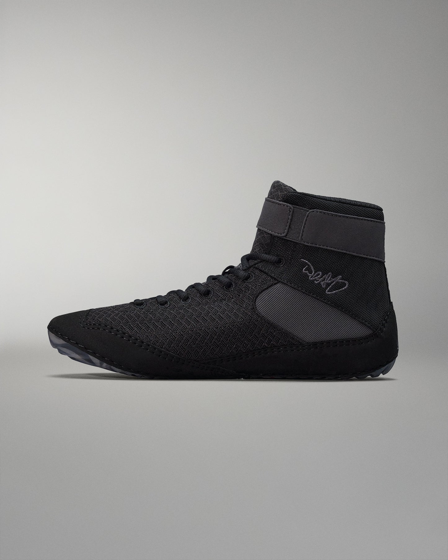 High-top athletic shoe with a breathable black mesh upper and padded ankle collar, designed for flexibility and grip, showcased against a soft gray background.