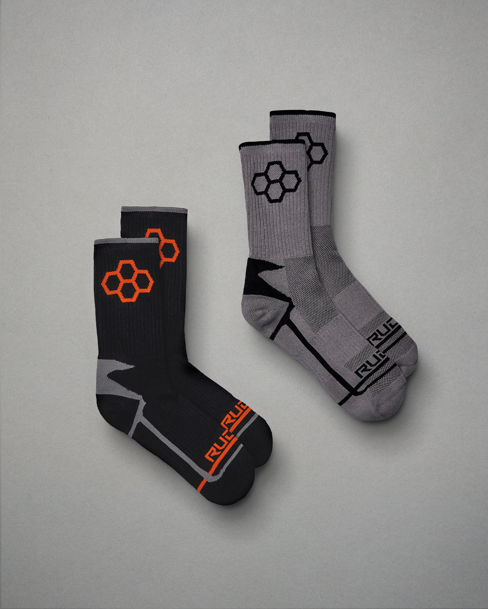 A pair of stylish athletic socks featuring a black design with orange accents and a gray design with black details perfect for enhancing comfort and performance in sports