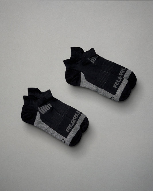 A pair of black athletic socks with gray accents and textured design elements displaying a modern aesthetic suitable for sports or casual wear