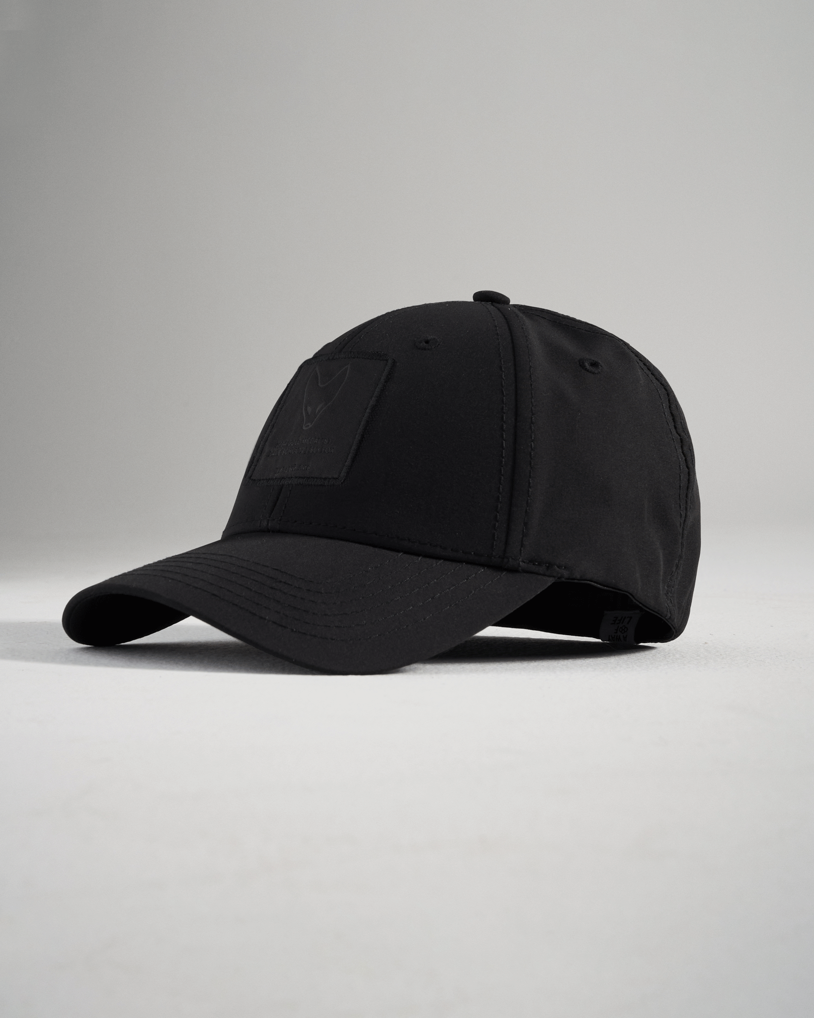 A sleek black cap with a textured logo patch on the front designed for casual wear