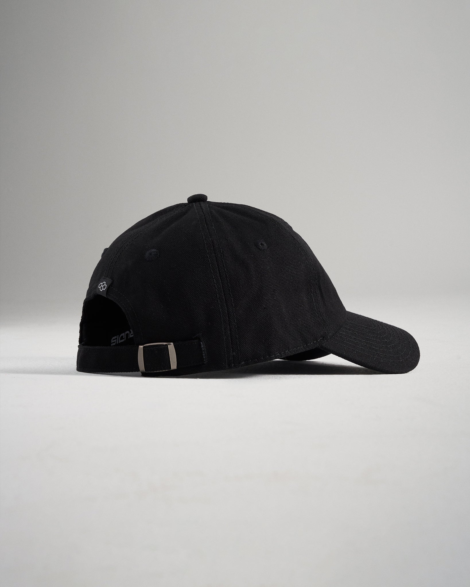 A stylish black baseball cap featuring a curved visor and adjustable strap at the back