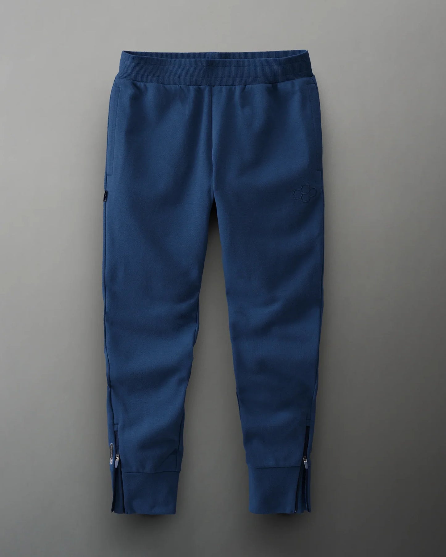 Navy blue joggers with a comfortable waistband, zippered side pockets for functionality, and a modern tapered design against a muted gray background.